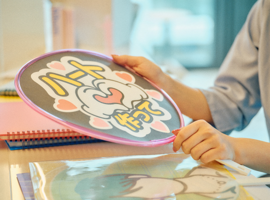 写真：インタビューでグッズを紹介する様子